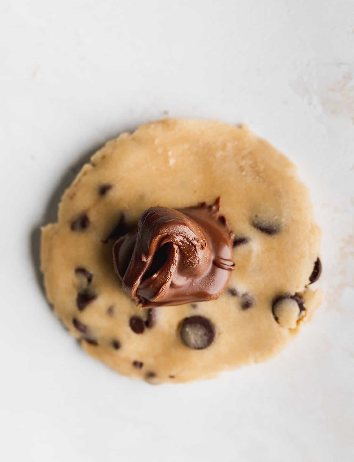 Flatten dough with Nutella drop on top.