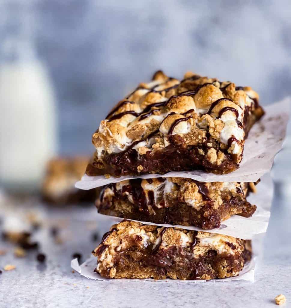 A stack of 3 easy s'mores bars with a glass of milk in the background