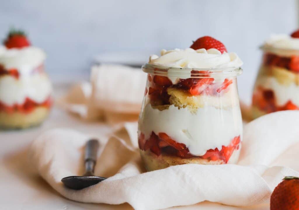 1 easy strawberry shortcake trifles in a jar on a flowing napkin.