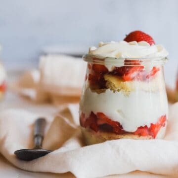 1 easy strawberry shortcake trifles in a jar on a flowing napkin.