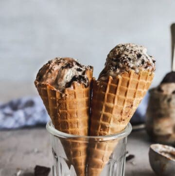 No-churn oreo and hot fudge ice cream make with sweetened condensed milk in 2 waffle cones.