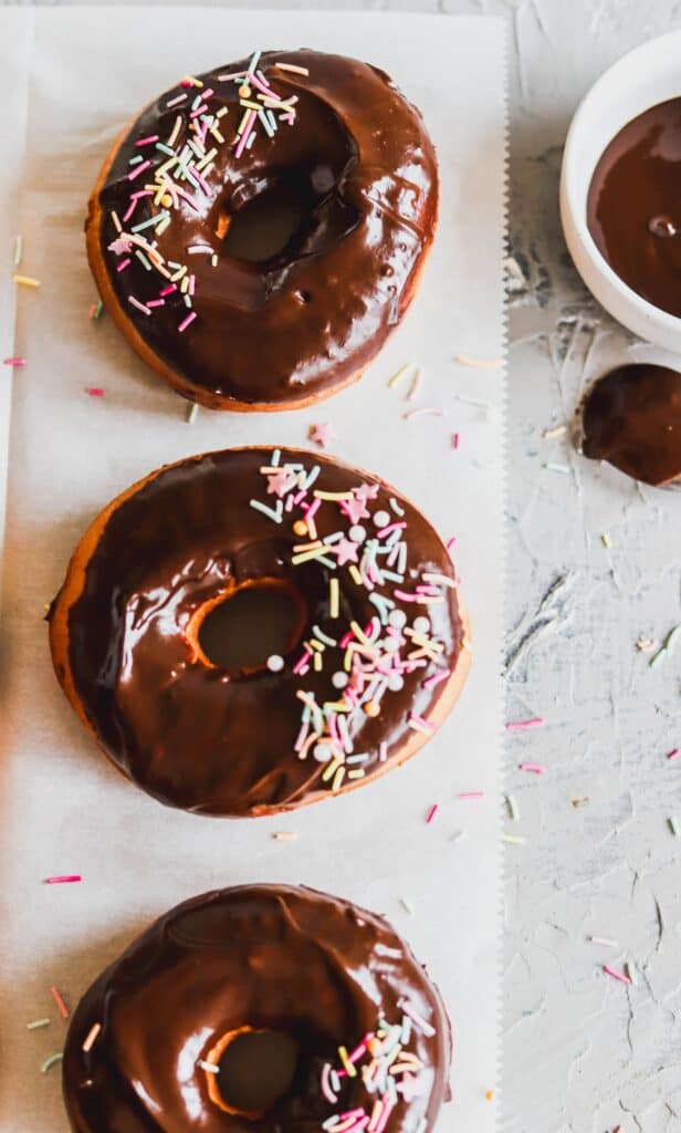 Chocolate glazed doughnuts are made with an easy chocolate glaze with no powdered sugar. Topped with sprinkles.