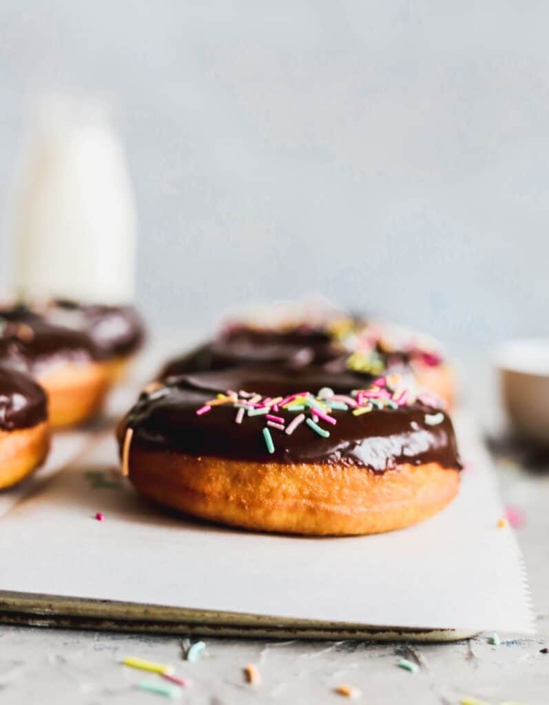 Side view of chocolate glazed doughnuts. This fluffy donut is full of air holes.