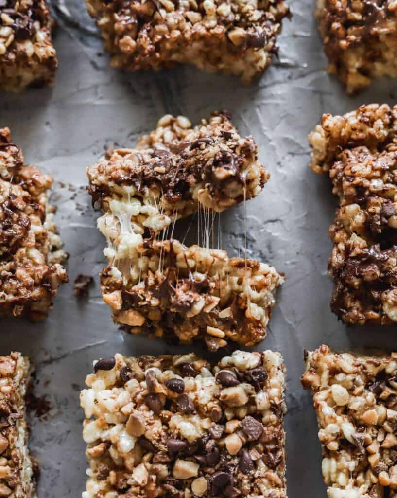 Rows of chocolate toffee rice krispie treats that are gooey and full of chocolate.