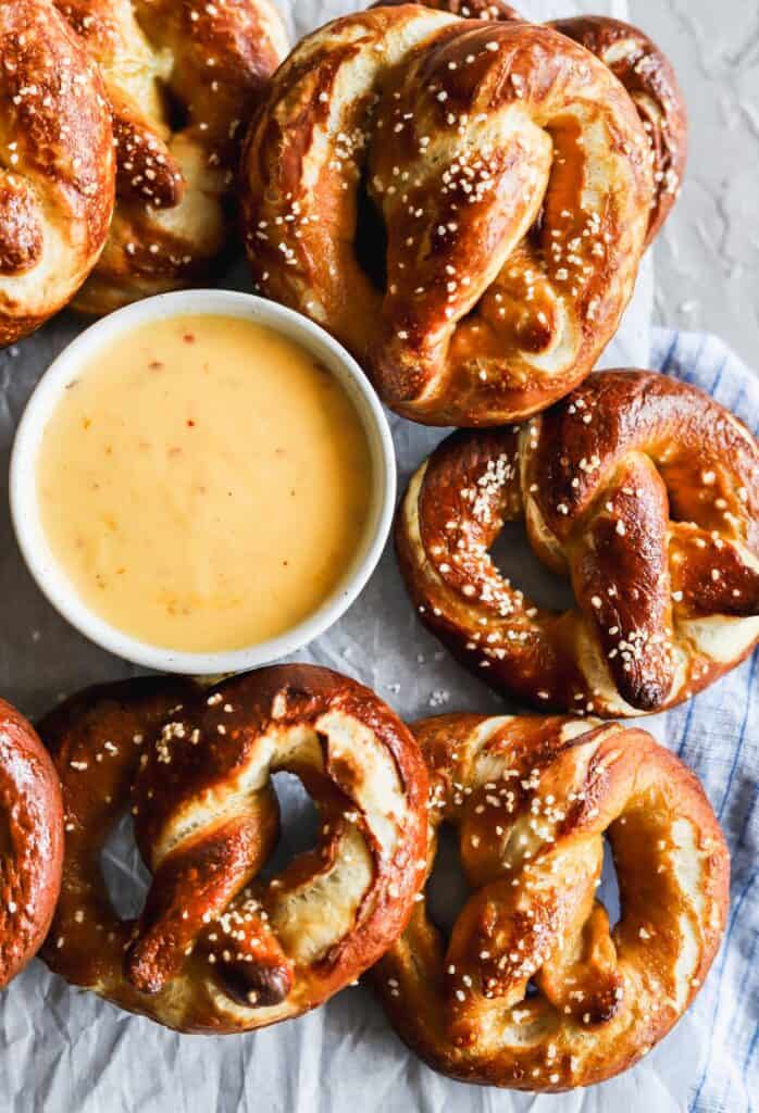 Easy soft buttery pretzels with a bowl of spicy cheese sauce.