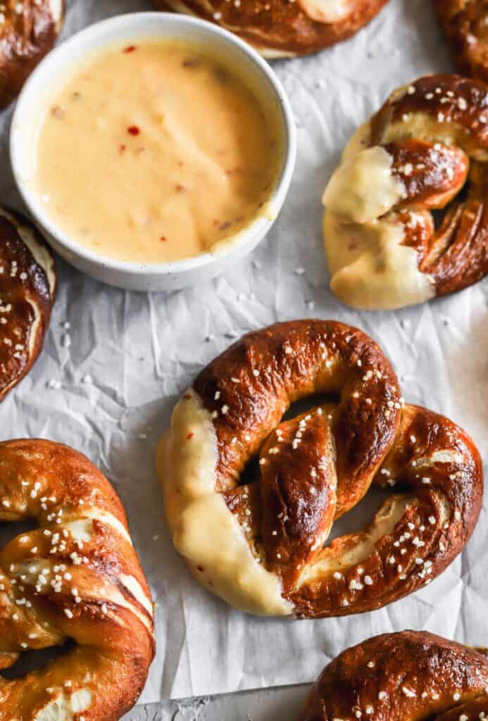 Homemade easy soft buttery pretzels with 2 pretzels dipped in spicy nacho cheese sauce.
