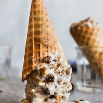 Salted caramel brownie ice cream in a waffle cone up side down showing the melted ice cream.