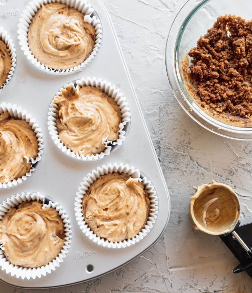 Cinnamon roll muffin batter in a jumbo muffin tin.