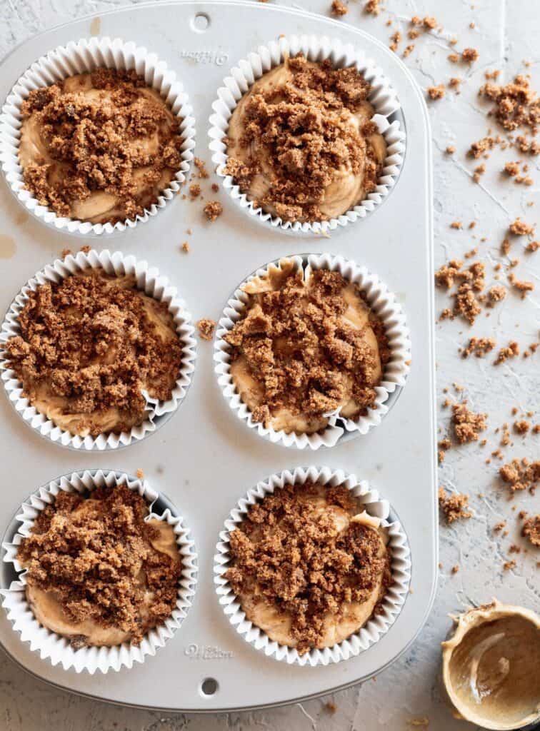 Cinnamon muffin with cinnamon roll topping on top in a jumbo muffin tin.