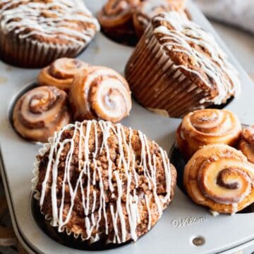 Close up of cinnamon roll muffin with cream cheese glaze drizzled on top.