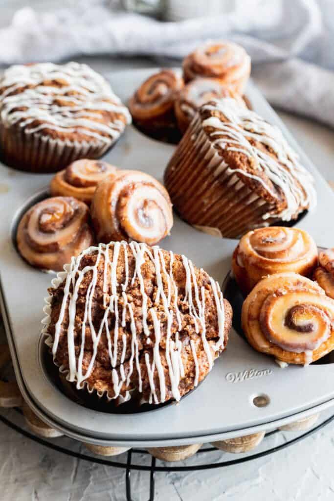 Close up of cinnamon roll muffin with cream cheese glaze drizzled on top.