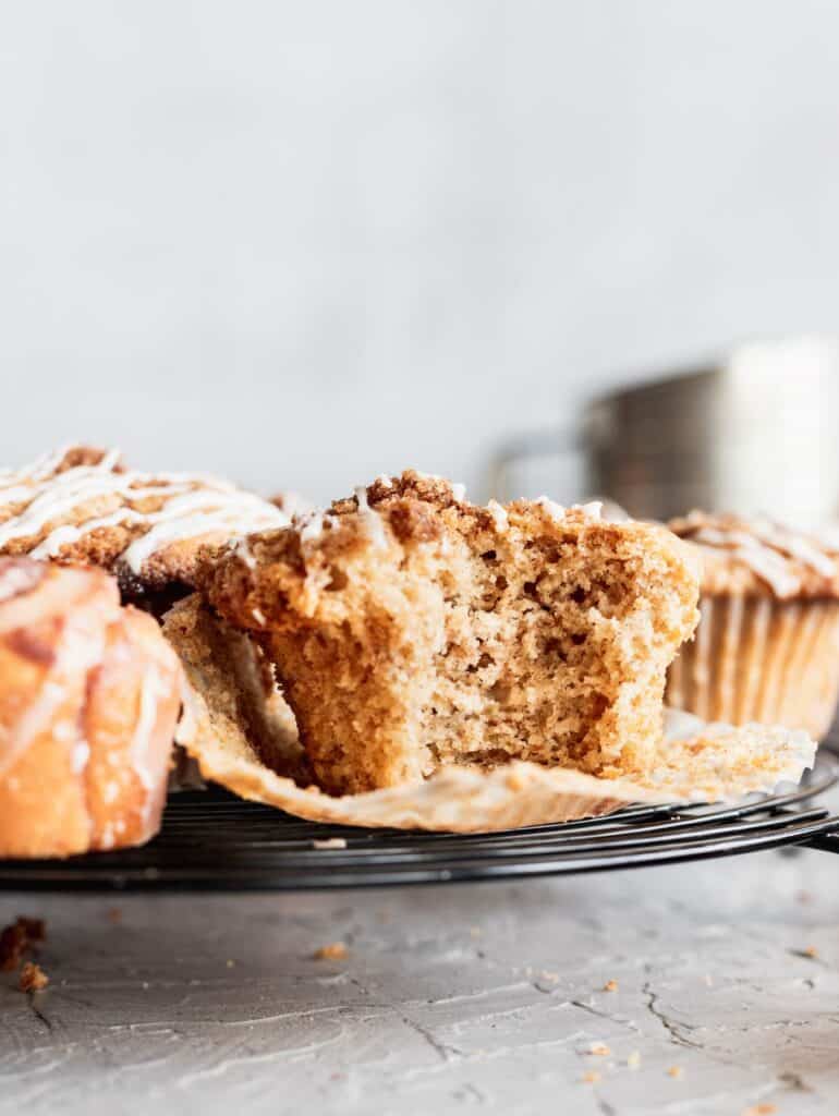 Cinnamon roll muffin with a bite taken out.