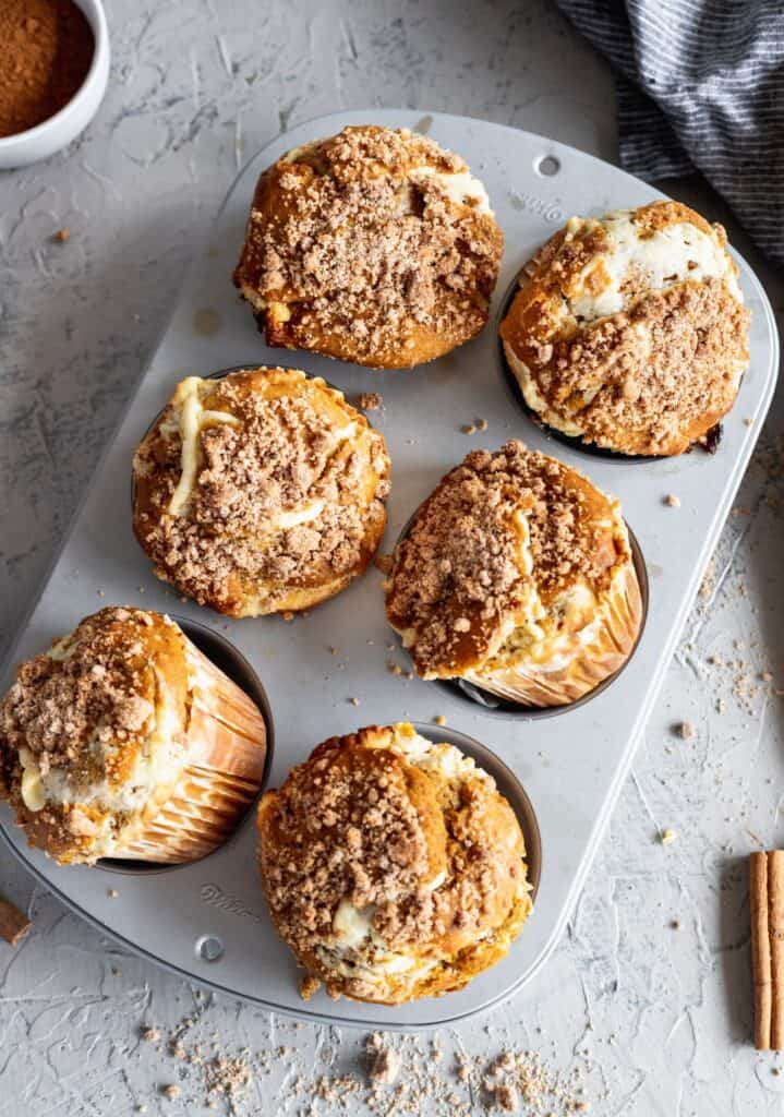 Pumpkin cheesecake swirl muffins showing off how big the jumbo muffins are.