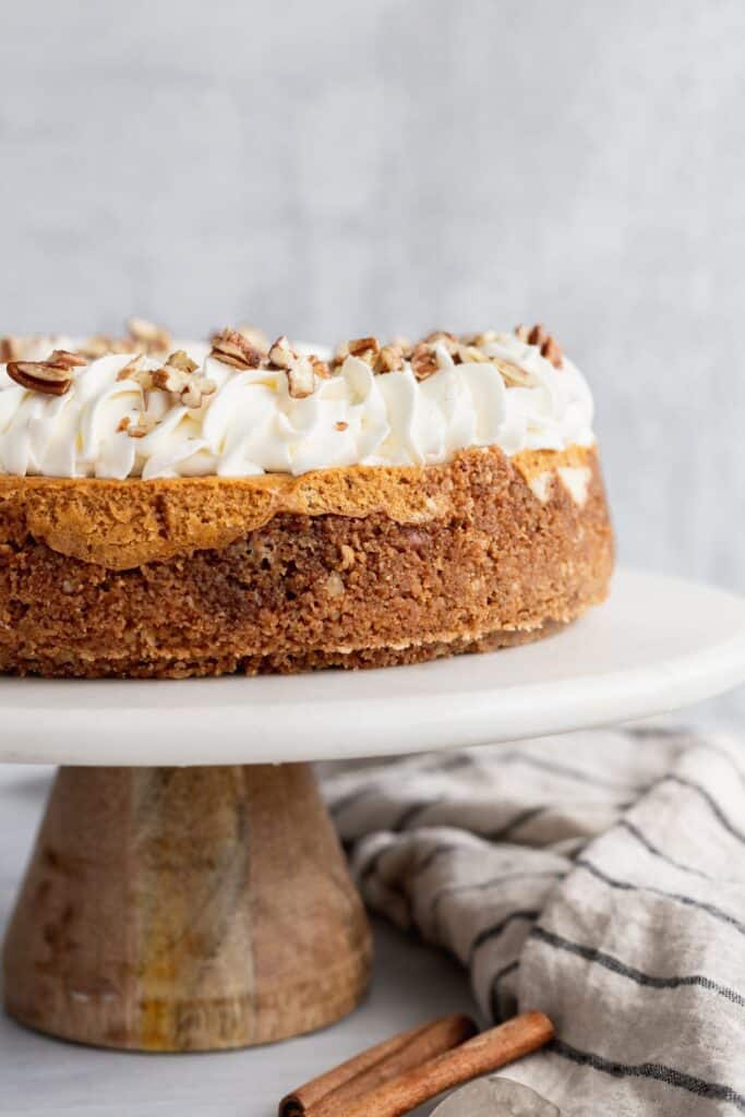 Double layer pumpkin cheesecake on a cake stand close up.