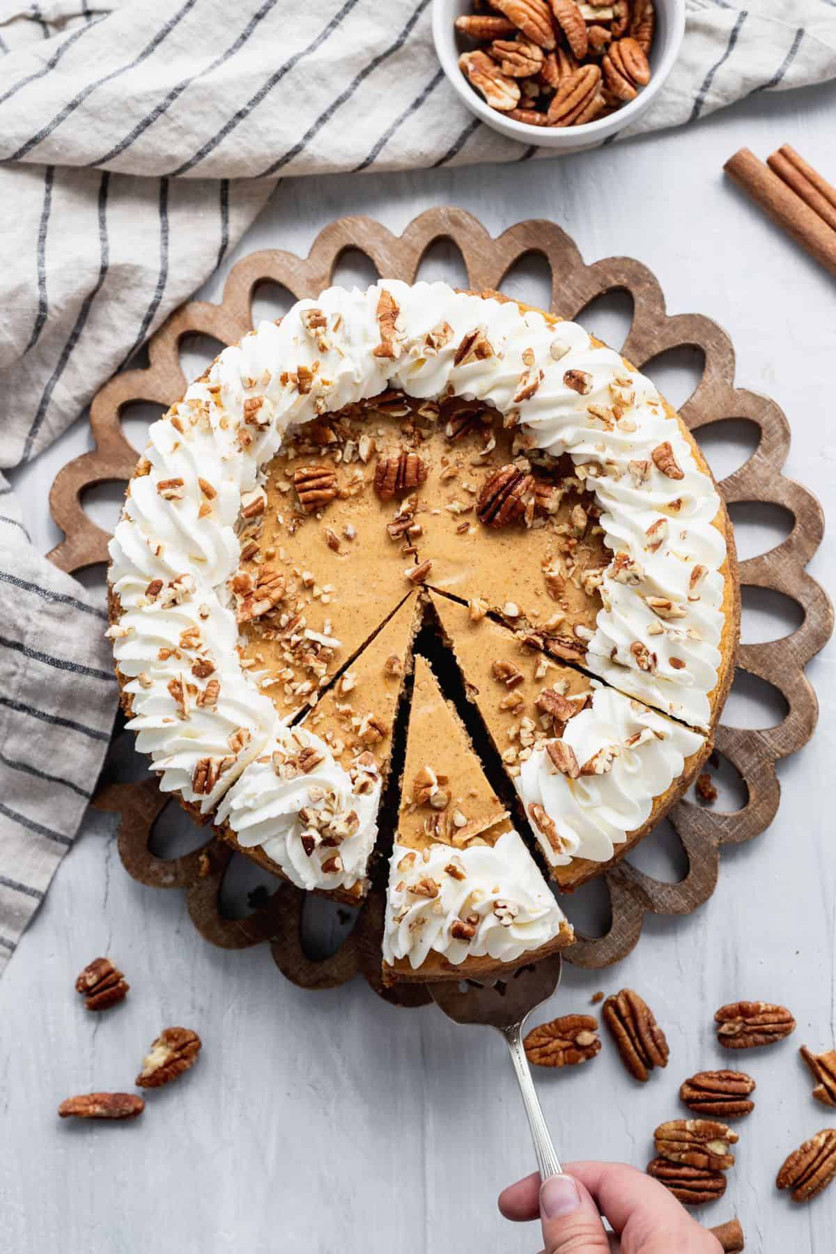 Top view double layer pumpkin cheesecake with 1 slice being removed.