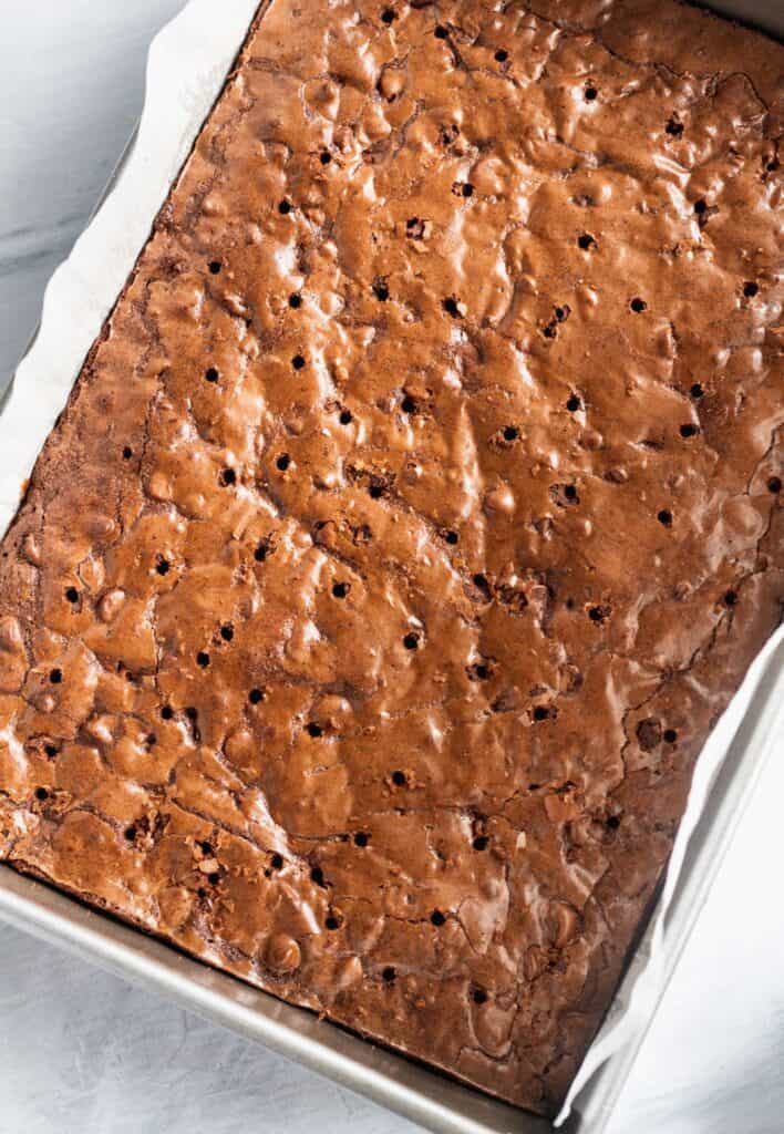 Tray of brownies with poked holes.