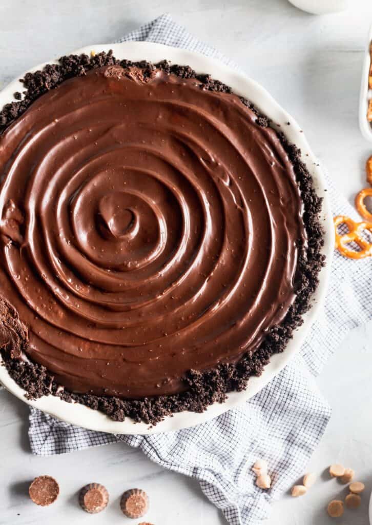 Chocolate ganache swirled on top of a a peanut butter pie.