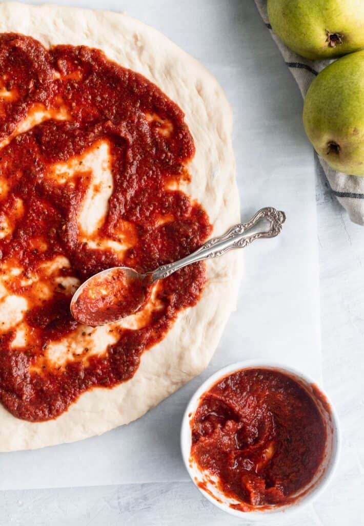 Homemade pizza sauce on top of a pizza dough.