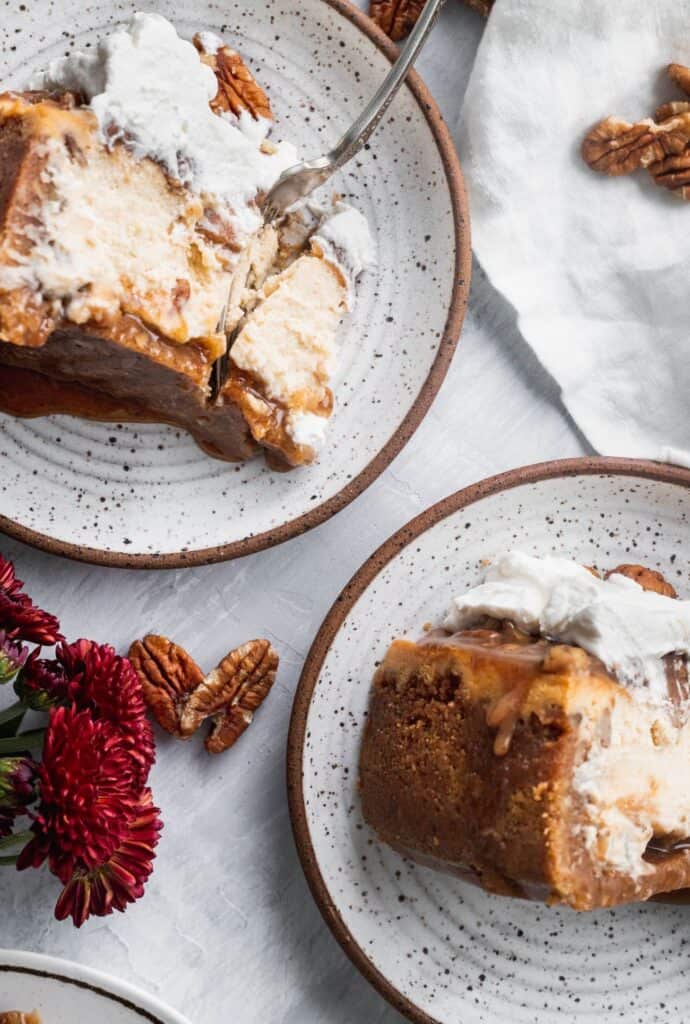 Cinnamon pecan pie cheesecake cut into slices on plates with 1 fork inserted.