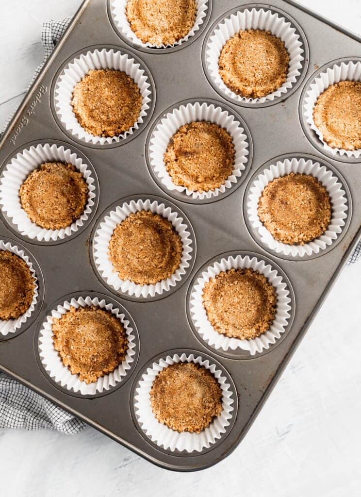 Graham cracker crust in a muffin pan.