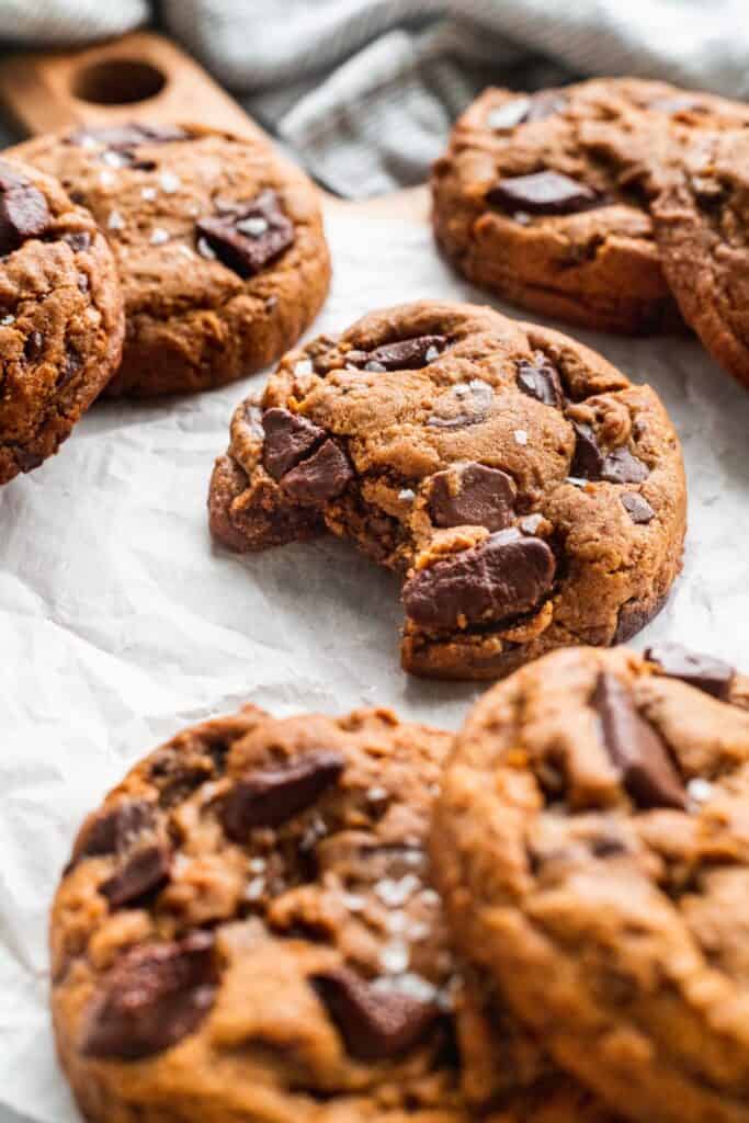 Side view of chocolate gingerbread cookies with a bite missing.