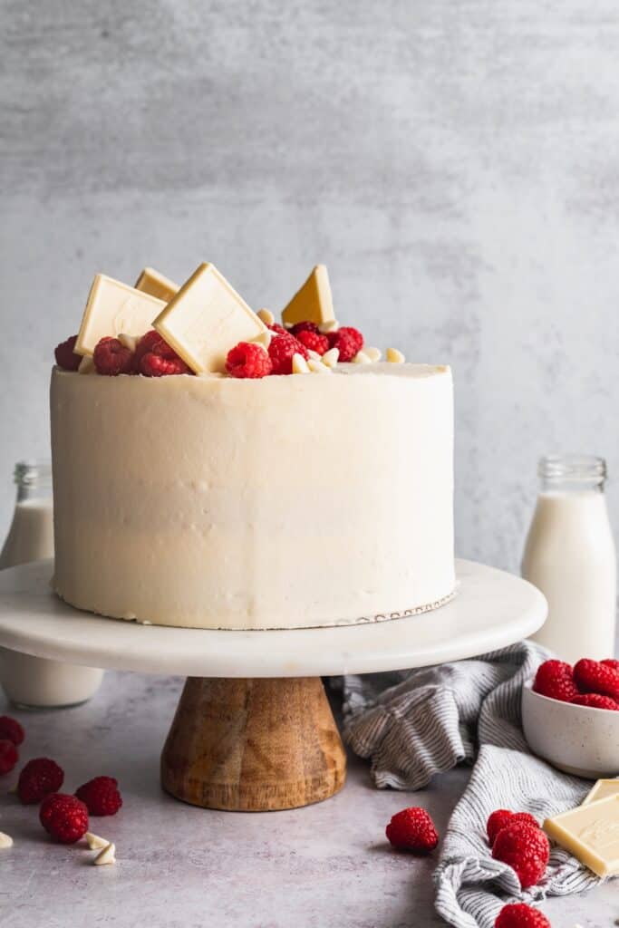 Raspberry white chocolate cake on a cake stand.