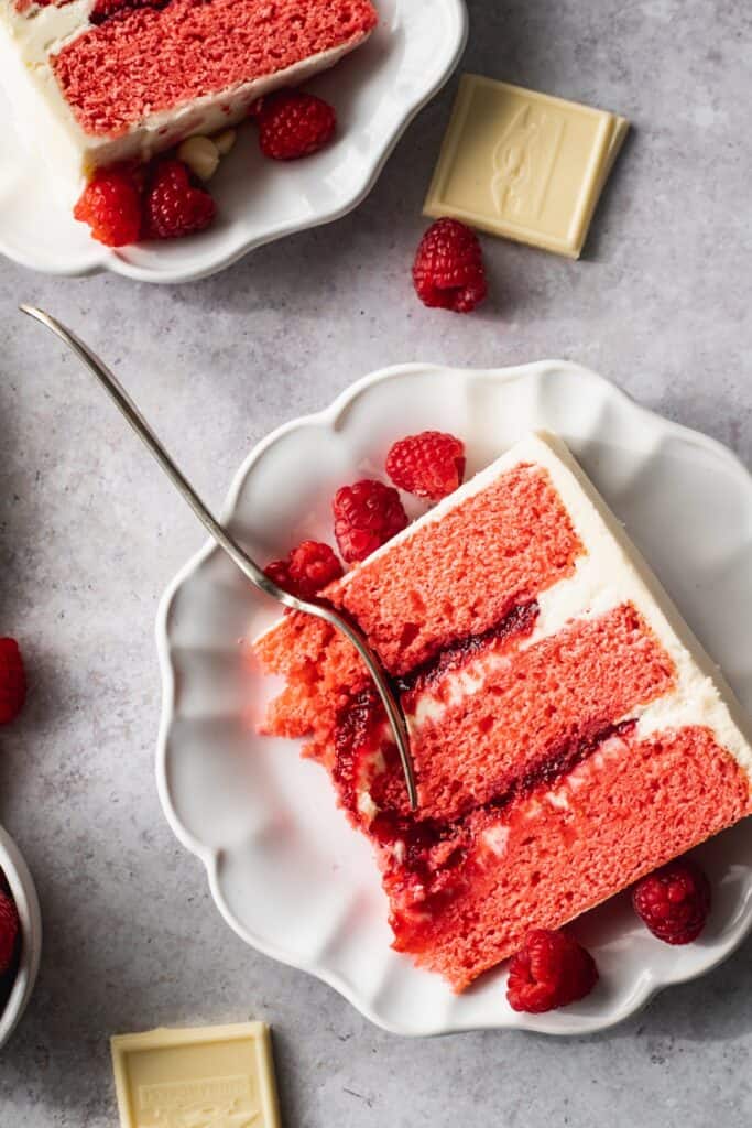 Raspberry white chocolate cake on a plate.