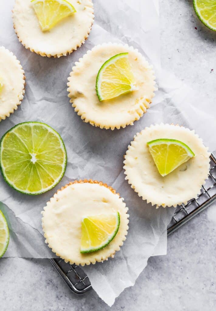 Little lime pieces on mini cheesecakes.