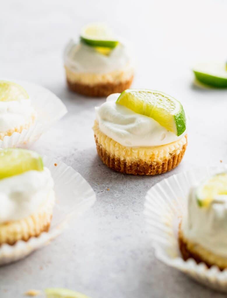 Mini key lime cheesecakes with fresh whipped cream on top.