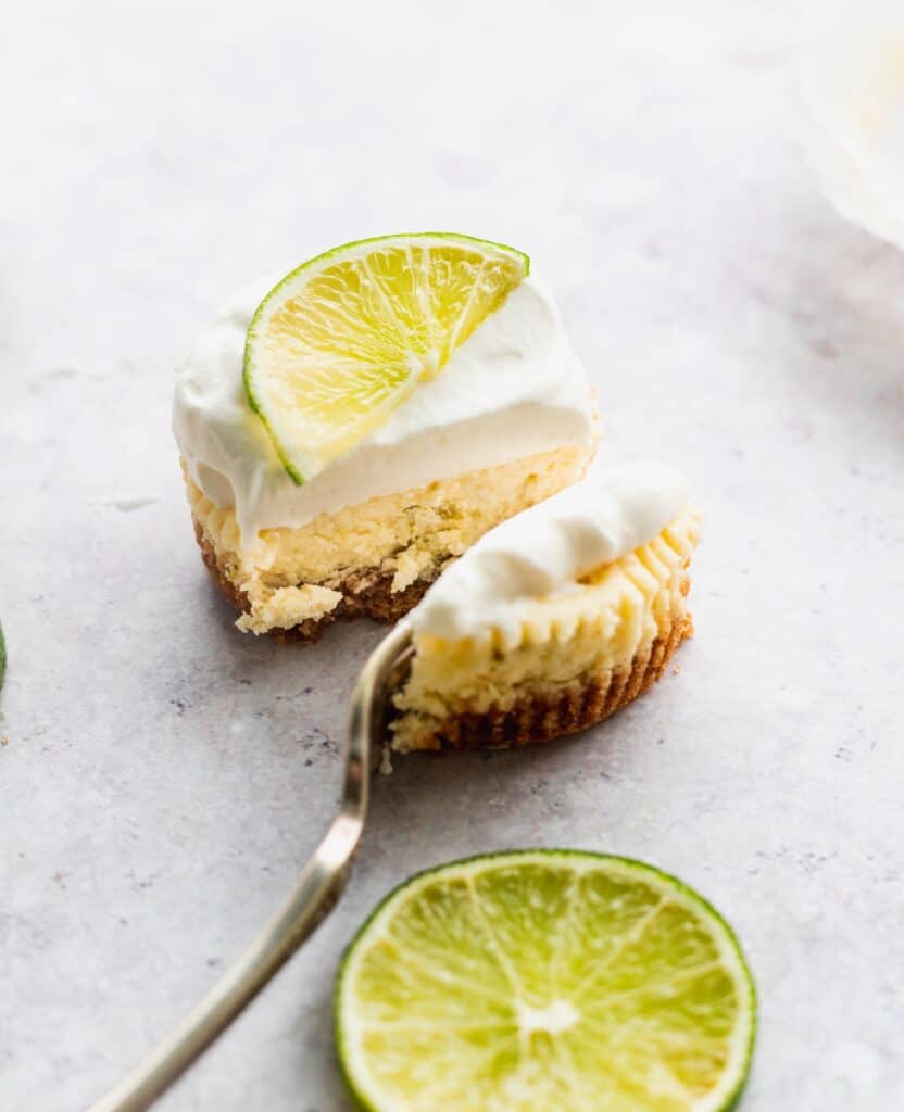 A fork biting into the mini cheesecakes.