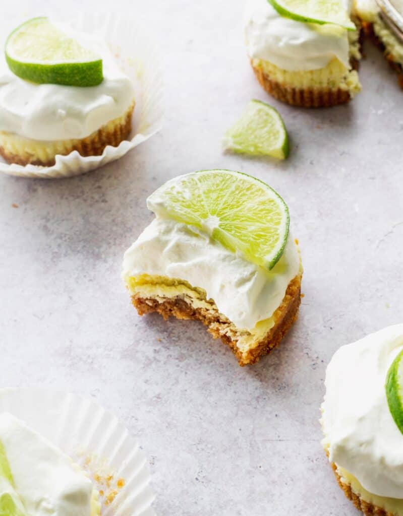 A bite missing from mini key lime cheesecakes.