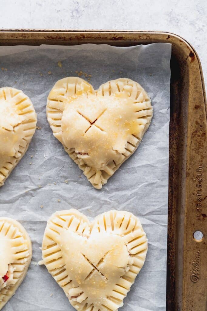 Pie hearts enclosed on a cookie sheet.