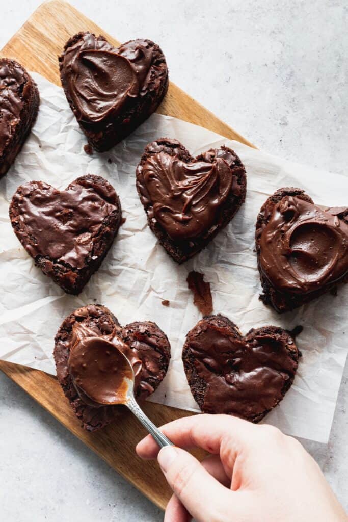 Spreading chocolate on top of brownies.