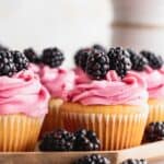 Blackberry cupcakes on top of a wooden board