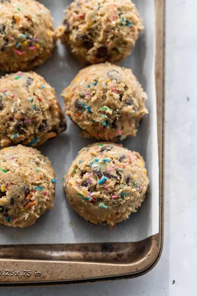 Cookie dough balls on a cookie sheet.