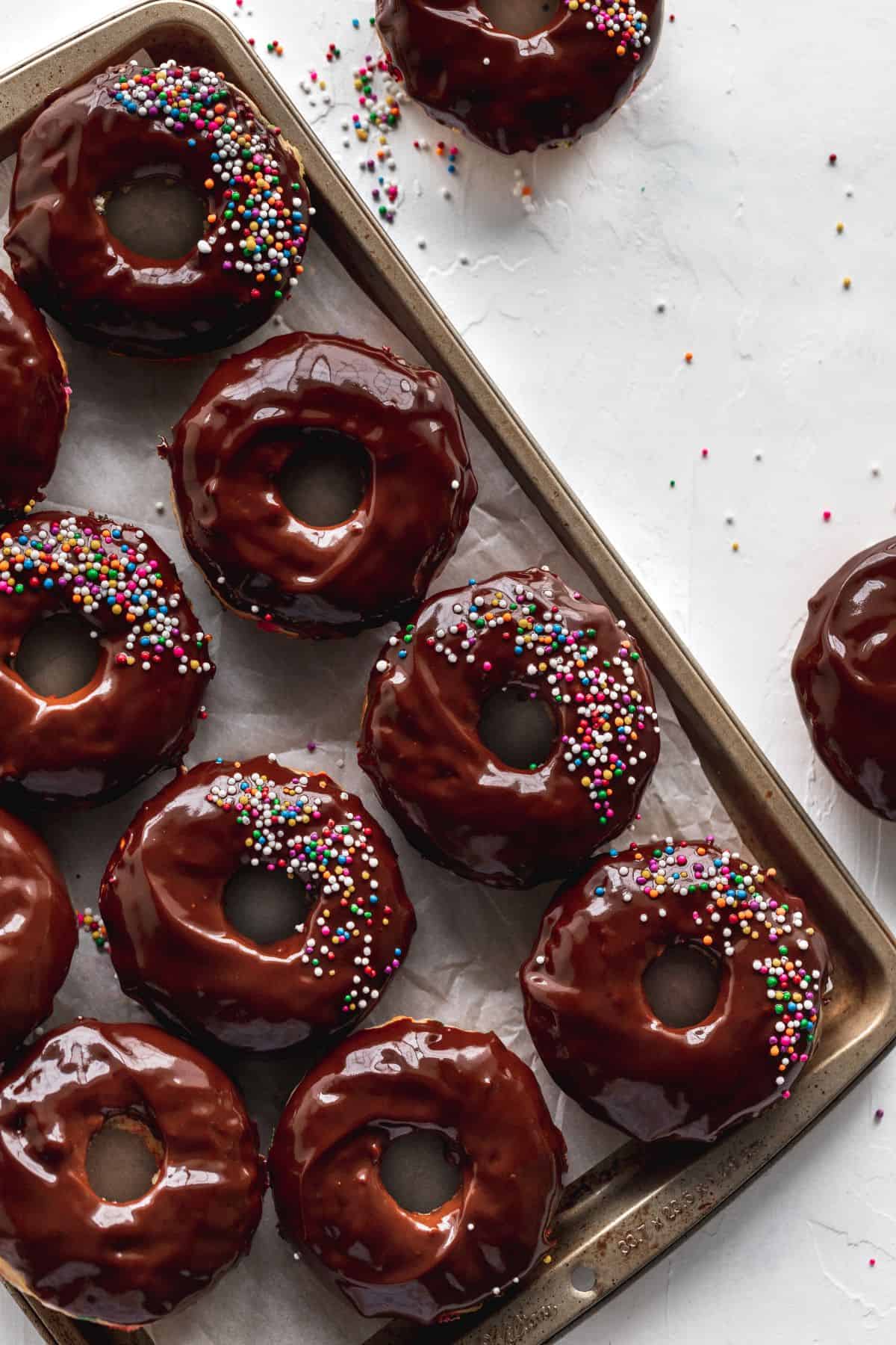 Birthday cake donuts on a cookie sheet.