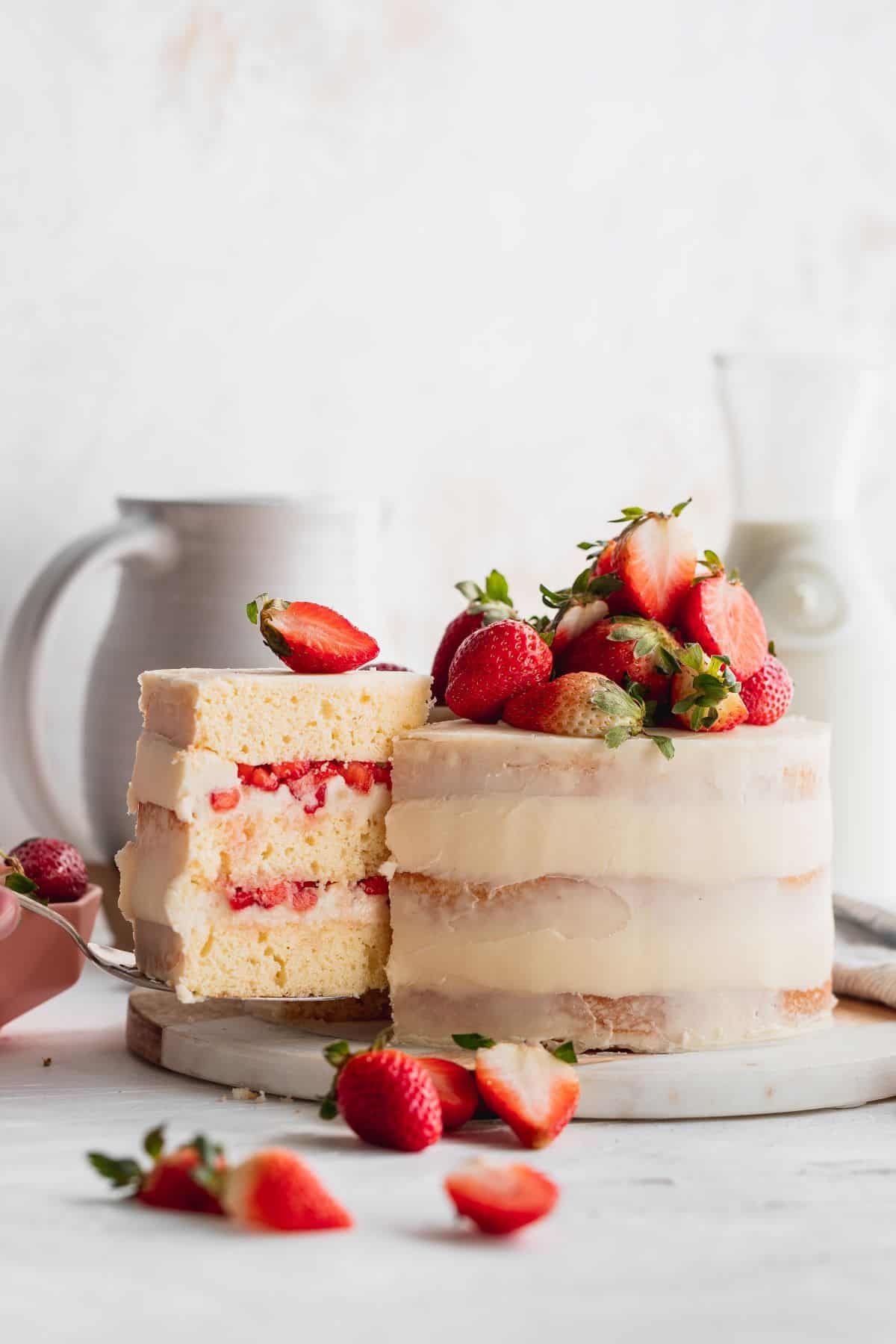 Taking a cake slice out of the strawberry semi-naked cake.