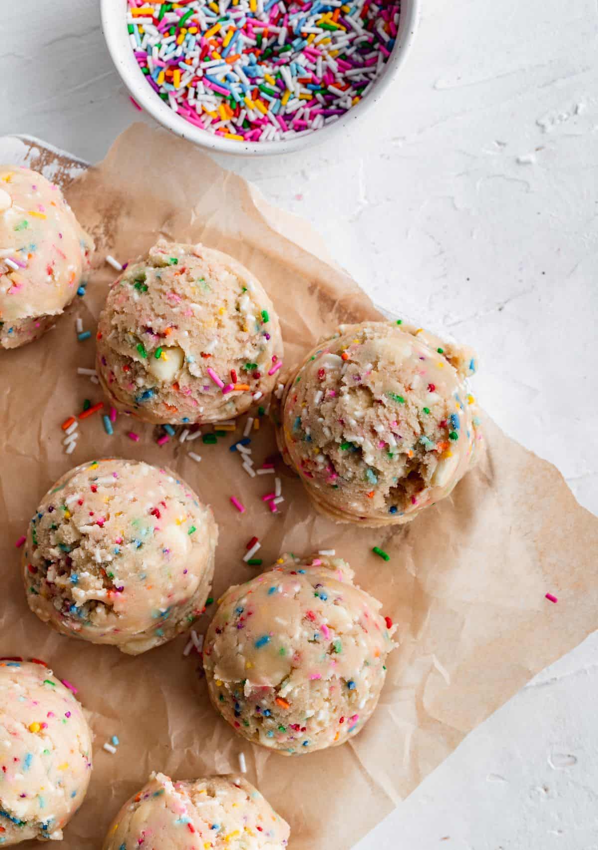 Funfetti edible cookie dough balls on parchment paper.