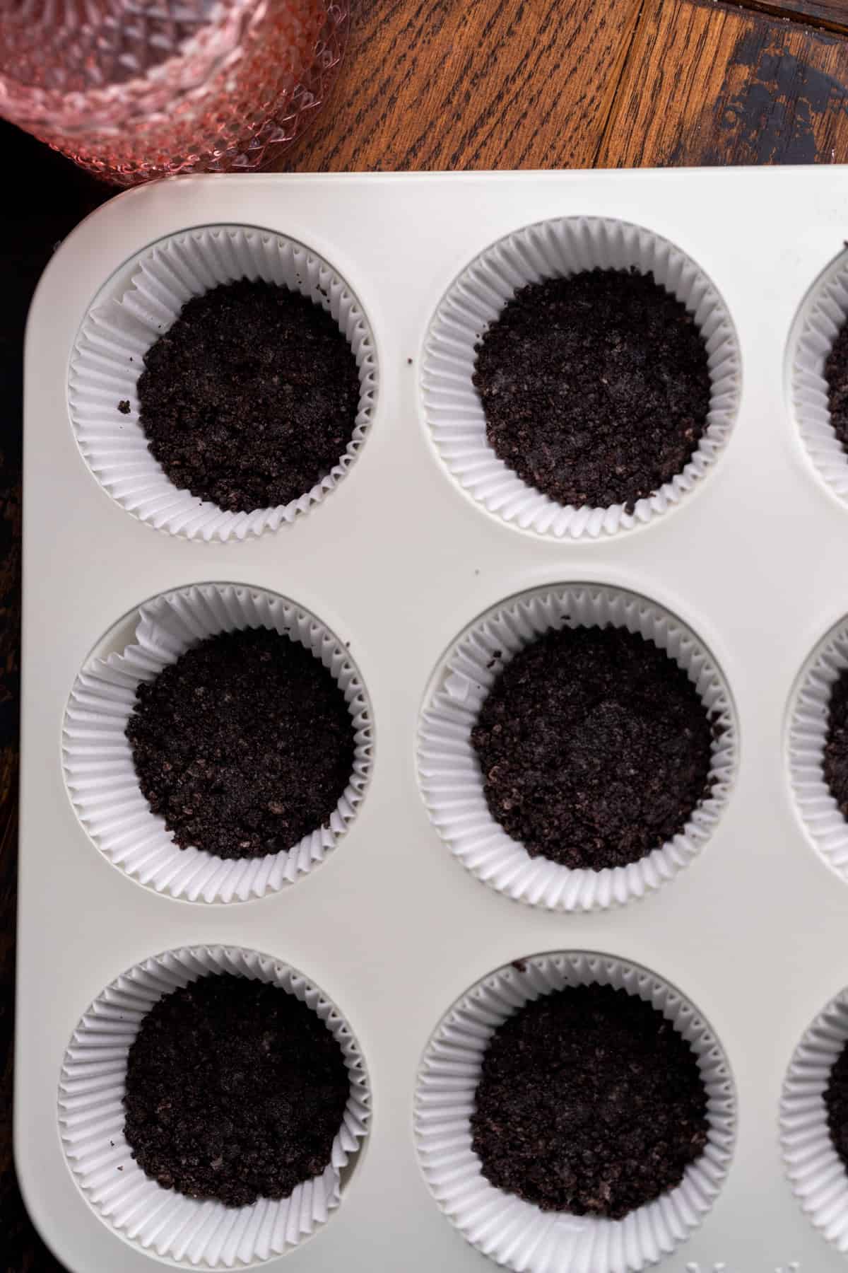 Oreo crust in a muffin pan.