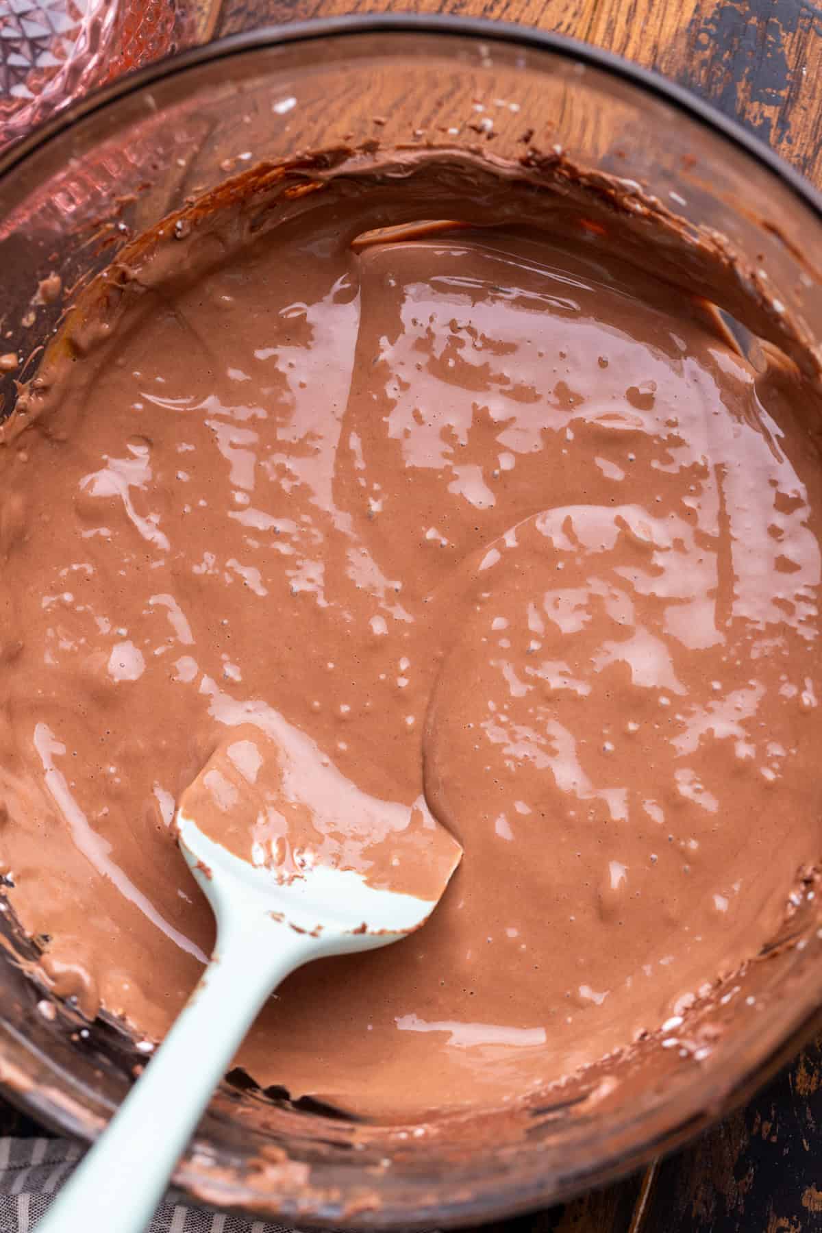Chocolate cheesecake batter in a glass bowl.