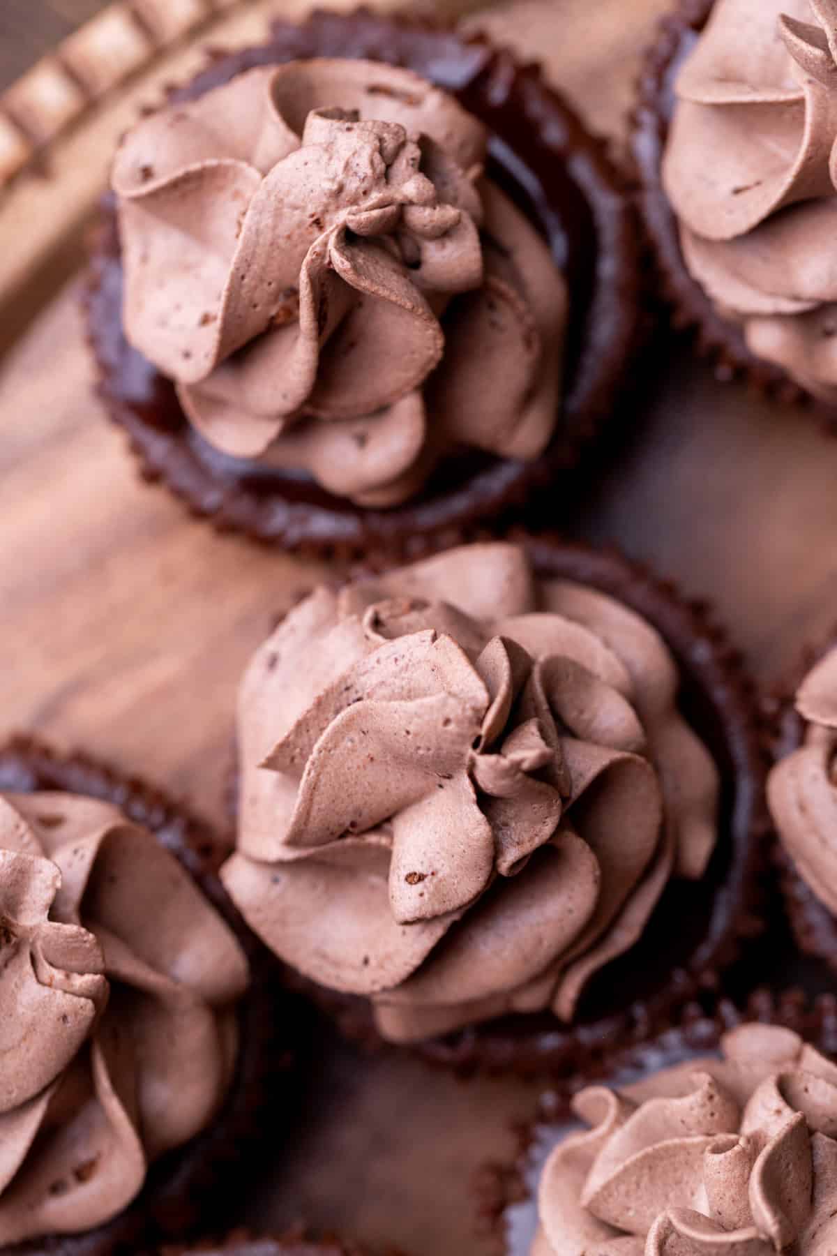 Chocolate whipped cream on top of cheesecakes.