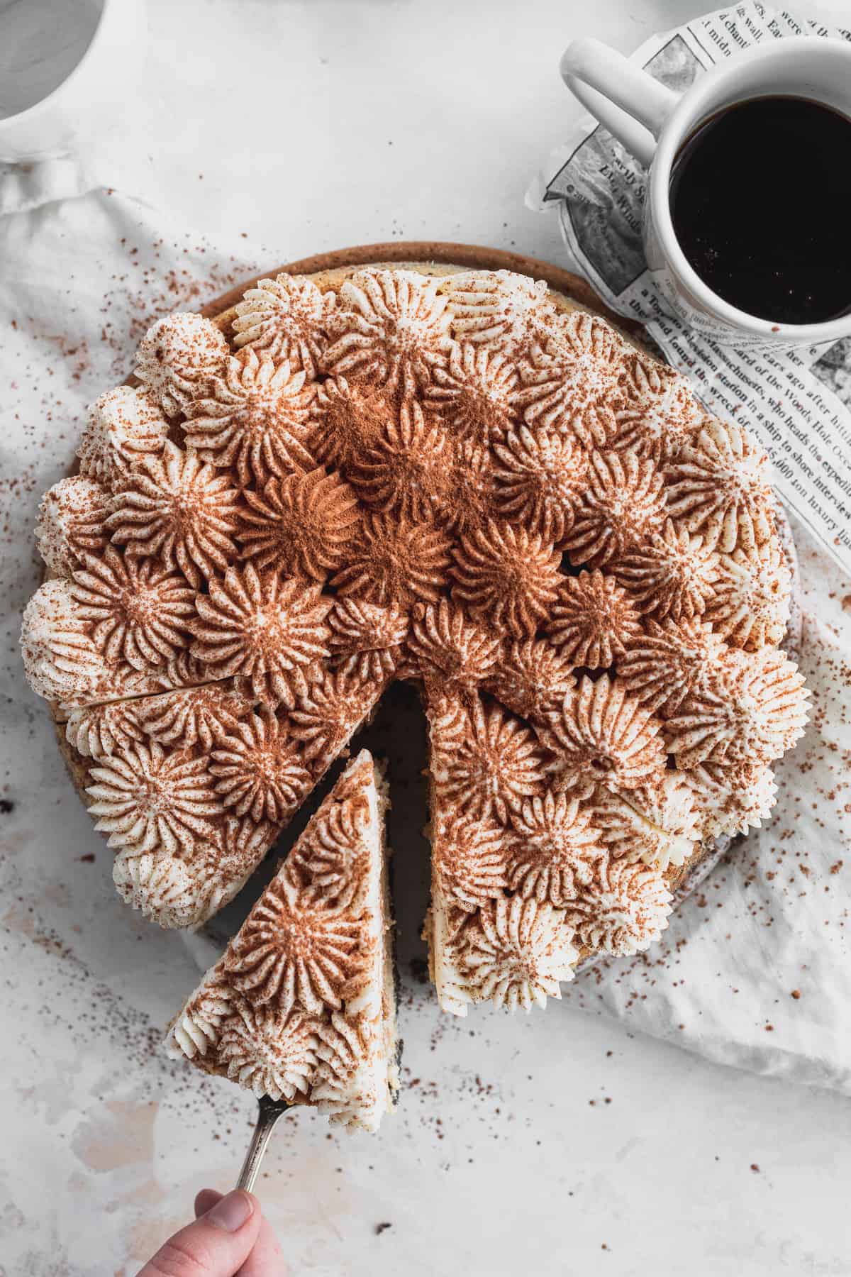 Top view of tiramisu cheesecake taking out a slice.