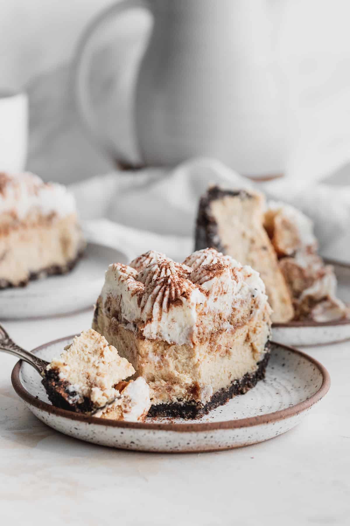 Slices of tiramisu cheesecake with a fork inserted.