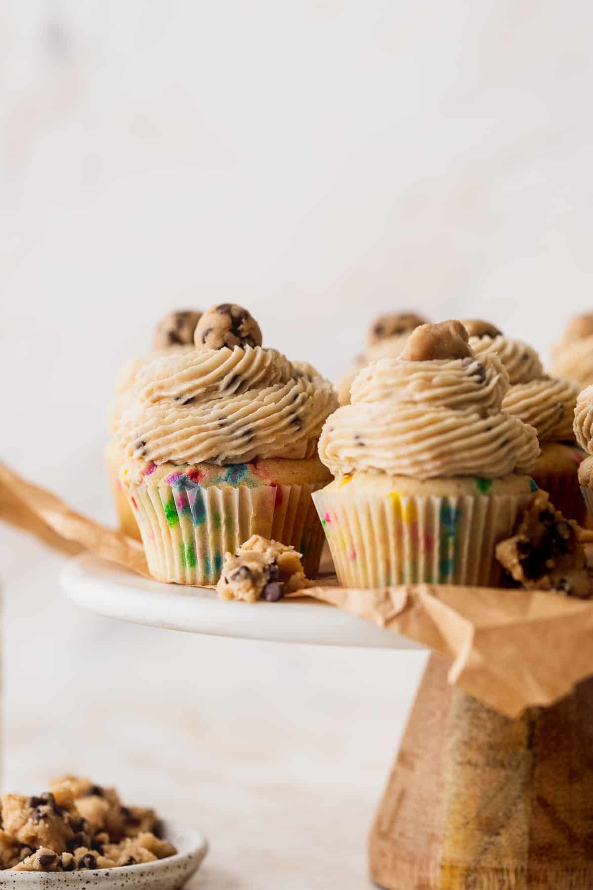 Cookie dough cupcakes on a cake stand.