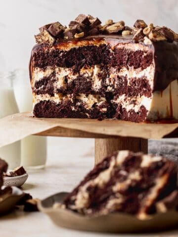Layered snickers cake open on a cake stand.