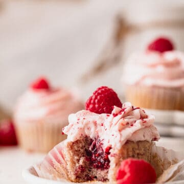 Bite missing from raspberry cupcakes.