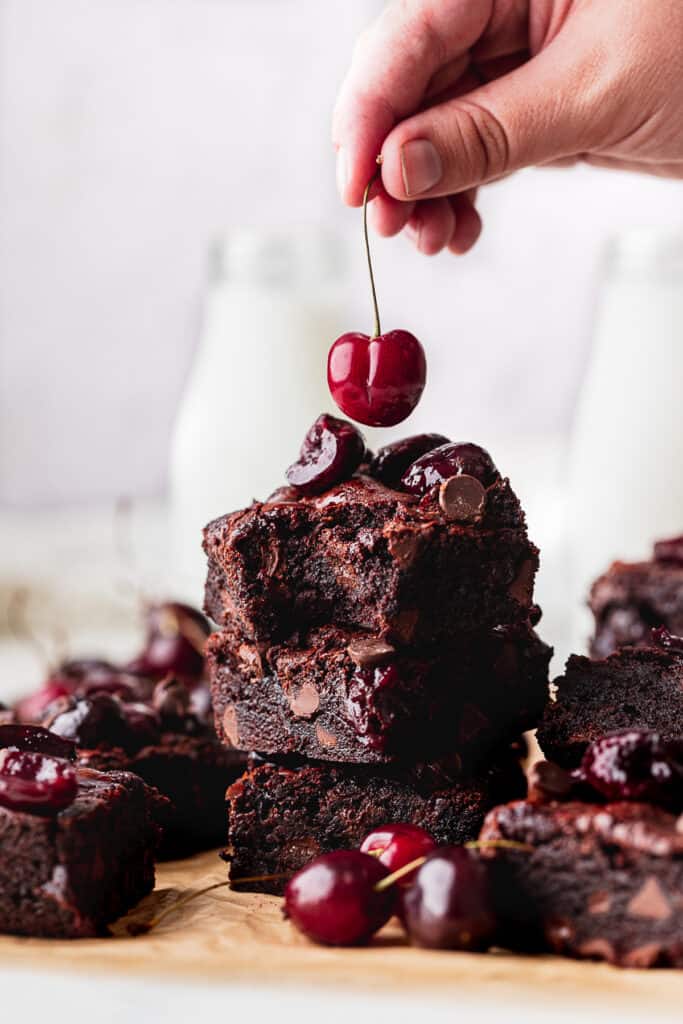 Dropping a cherry on to the cherry brownies.
