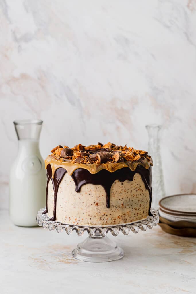 Butterfinger cake on glass cake stand.