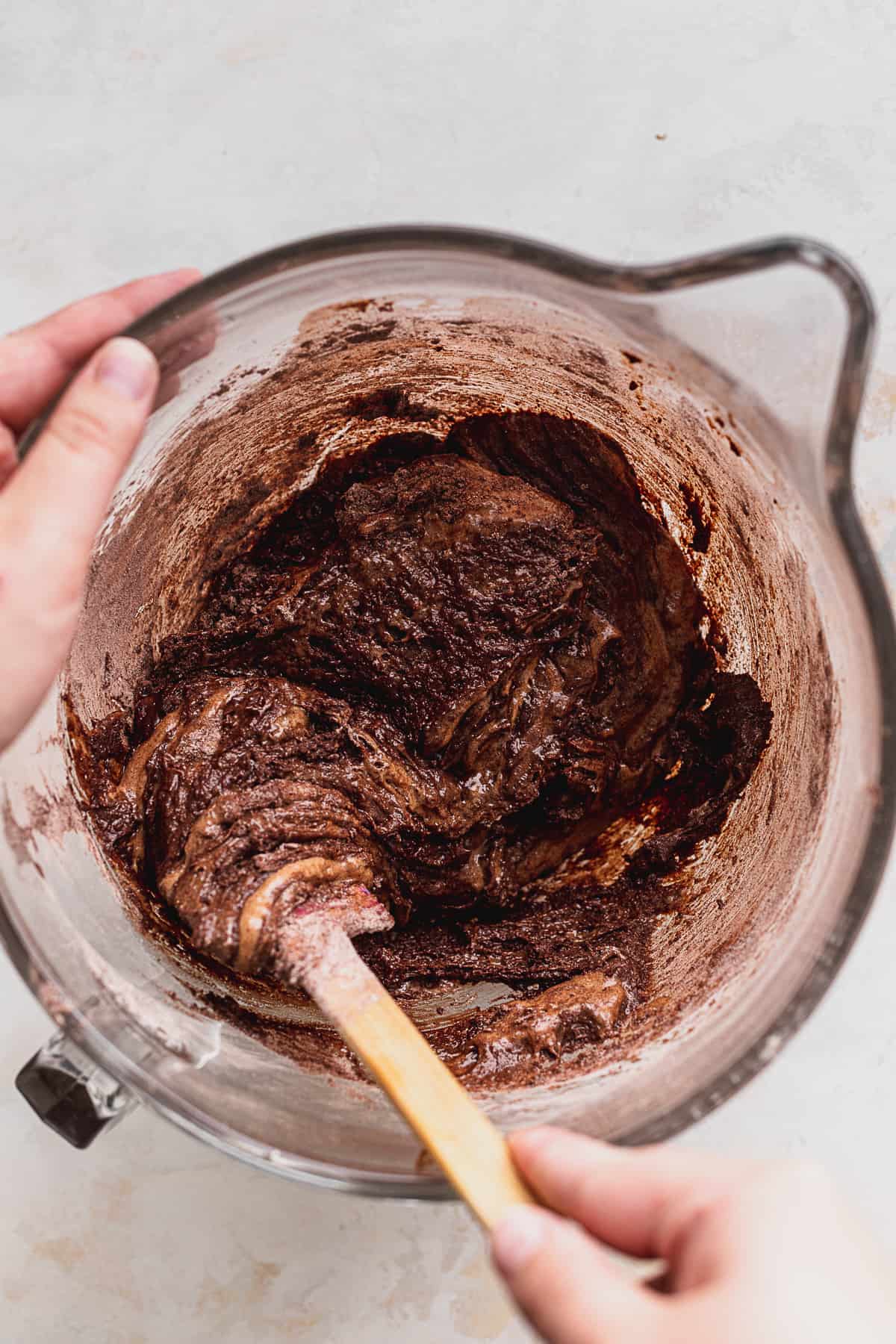 Mixing brownie batter in glass bowl.