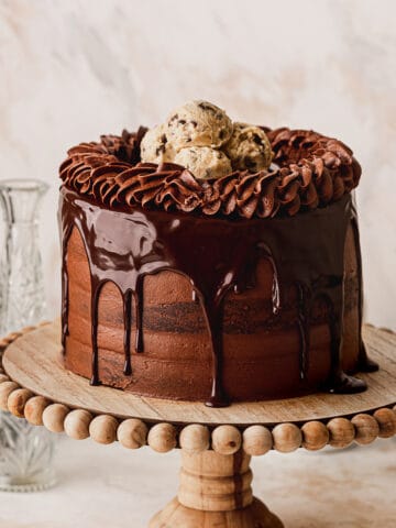 Chocolate brownie cookie cake on a cake stand.